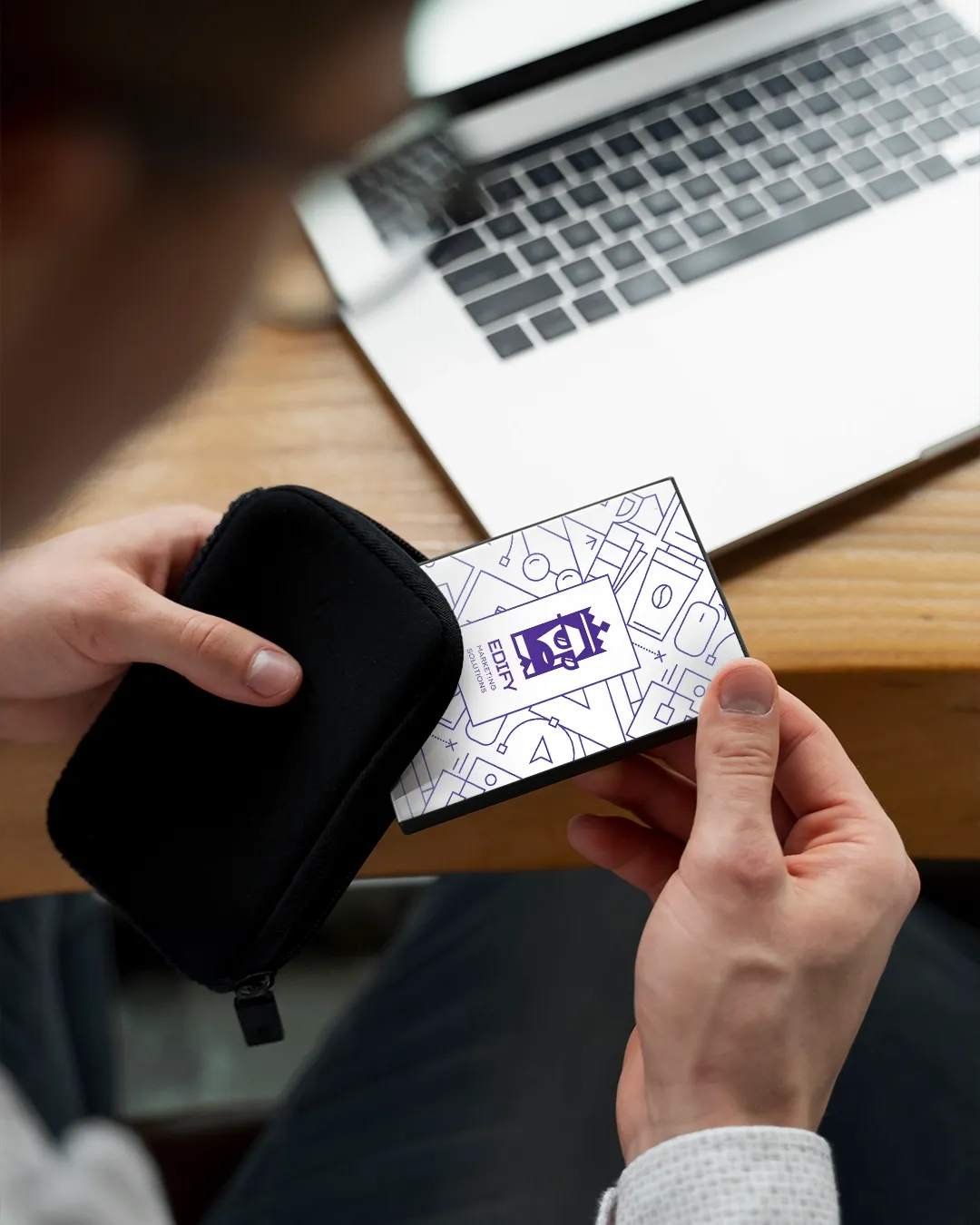A hand holding a Wink card near a phone